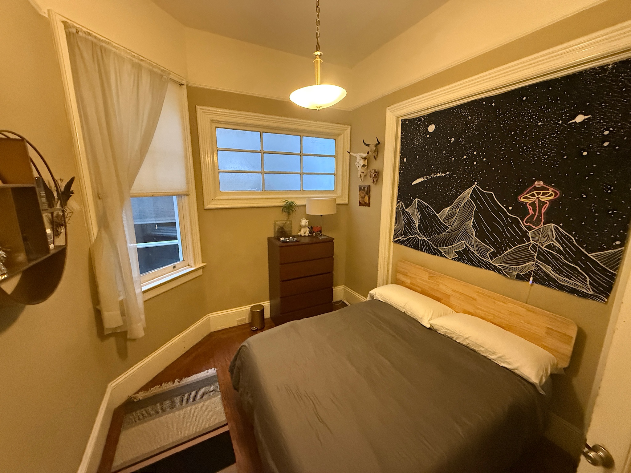Bedroom with starry night mural and dark bedding
