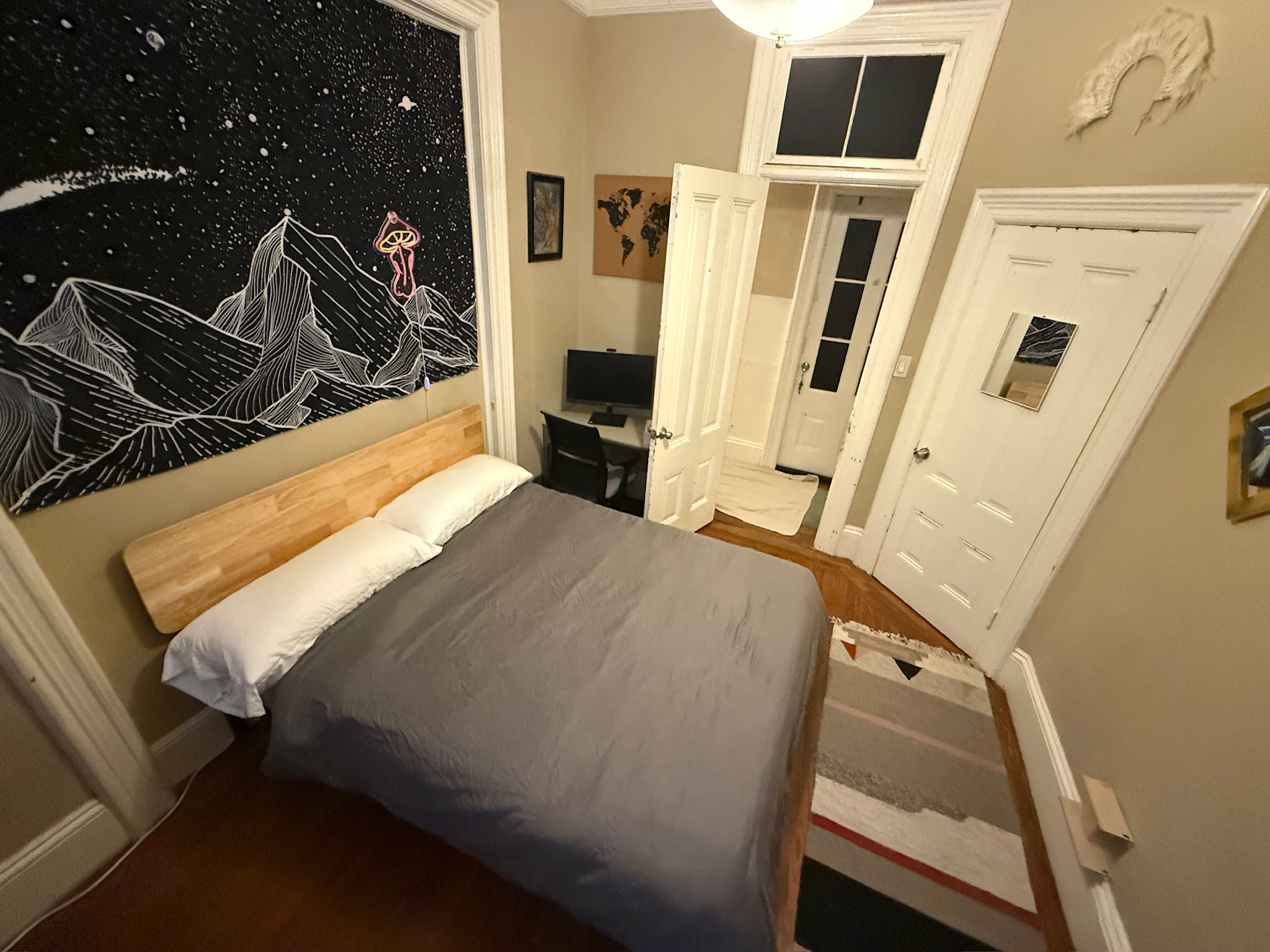 Bedroom with space/mountain mural wall art and wooden bed
