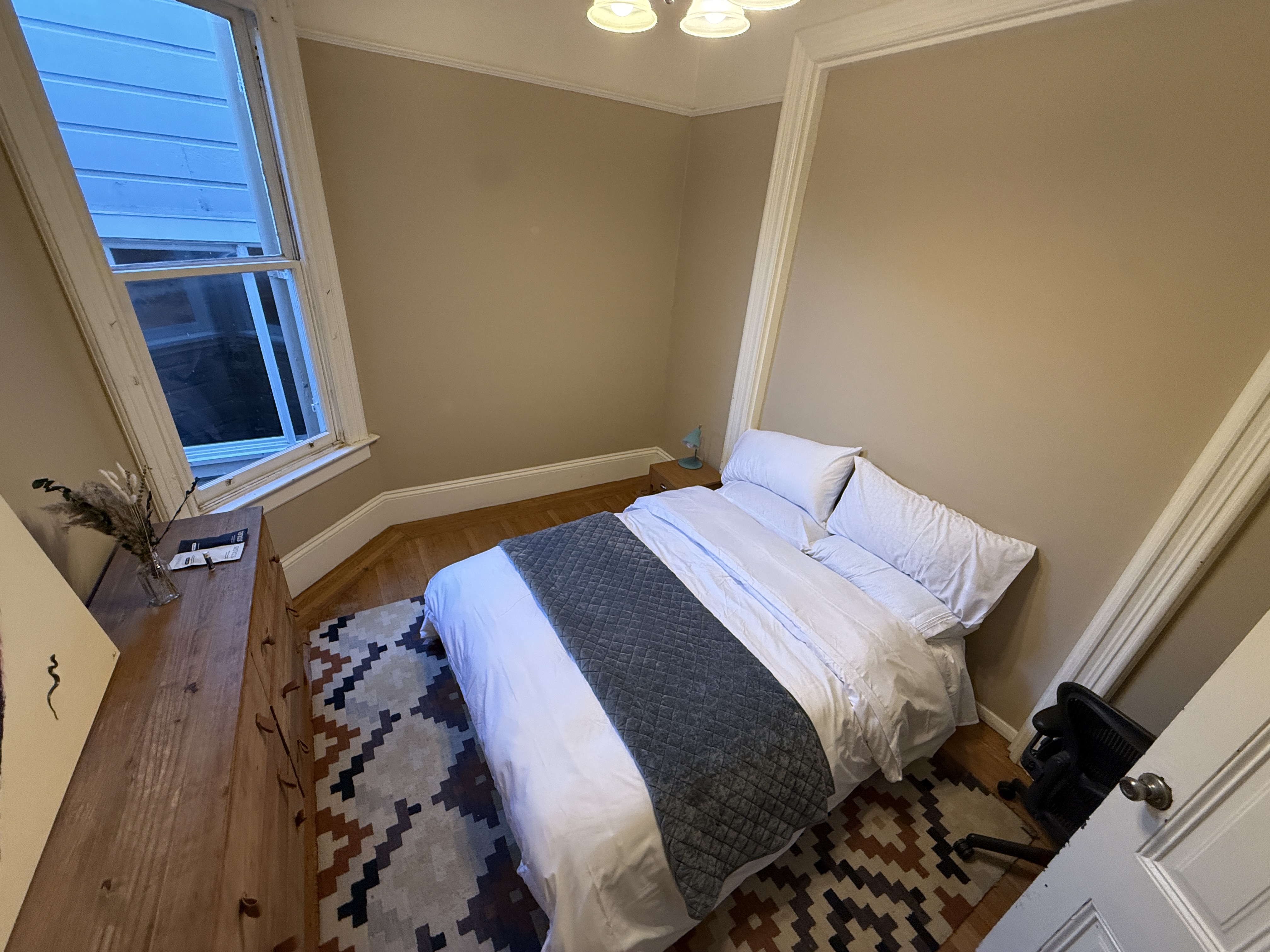 Bedroom with window view and patterned rug